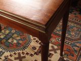 a small wooden table with a wooden top on a rug