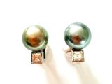 une paire de boucles d'oreilles en perles et diamants posées sur un fond blanc