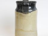 a black and white vase sitting on a white surface