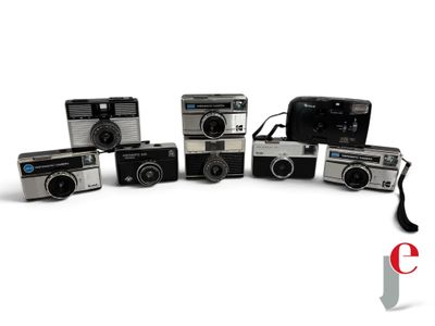 five cameras sitting next to each other on a white surface