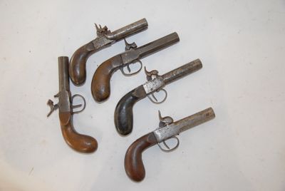 three old revolvers sitting on a white surface with a white background
