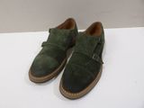 a close up of a pair of green shoes on a white surface
