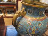 a blue vase with a gold handle sitting on a table