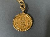 an image of a gold coin on a chain with a crown on it
