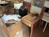 une pile de cartons et une chaise au milieu d'une pièce encombrée