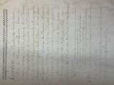 an old document with writing on it sitting on a table