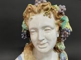 a figurine of a woman with grapes on her head