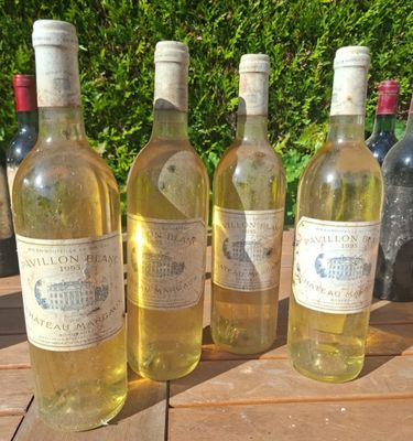 plusieurs bouteilles de vin sont alignées sur une table en bois