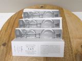 three boxes of soap sitting on top of a wooden cutting board