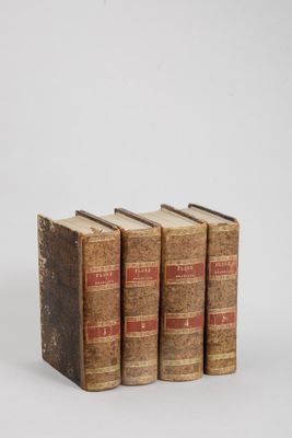 three old books sitting on top of each other on a white surface