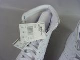 a pair of white sneakers with a price tag on them