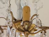 a gold chandelier with crystal beads hanging from it ' s ceiling