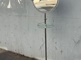 un miroir posé sur un pied près d'un mur