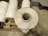 a roll of toilet paper sitting on a pallet next to some rolls of toilet paper
