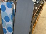 two ironing boards sitting on a rack in a room