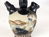 a vase with a painting on it on a white surface
