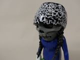 a figurine of a skeleton wearing a helmet and holding a tennis racquet