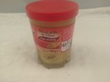 un pot de beurre de cacahuète posé sur une surface blanche