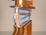 une sculpture en bois représentant un homme coiffé d'un chapeau