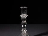 a glass candle holder sitting on a black table