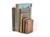 plusieurs vieux livres sont empilés sur une surface blanche