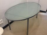 a glass table with a chair in the corner of the room