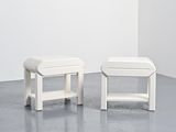 une paire de tabourets blancs dans une pièce blanche aux murs blancs