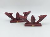 deux bougeoirs rouges posés l'un sur l'autre sur une surface blanche