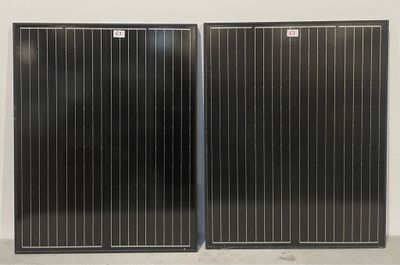 une paire de panneaux solaires noirs sur un mur blanc dans une pièce