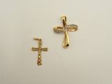 two gold crosses and a diamond cross on a white surface