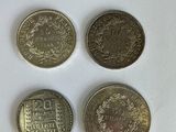 quatre pièces de monnaie britanniques différentes posées sur une surface blanche