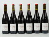 six bouteilles de vin sont alignées sur une table