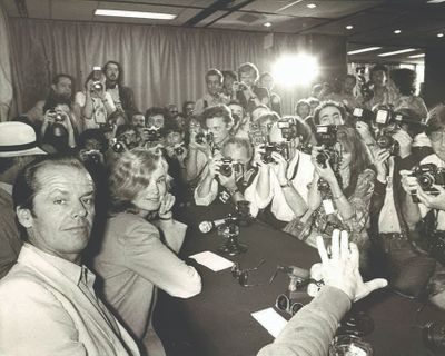 photographie en noir et blanc d'un groupe de personnes assises autour d'une table