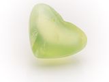 a green heart shaped piece of glass on a white surface