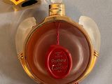a red and gold perfume bottle with a red cap