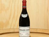 a bottle of wine sitting on top of a wooden barrel