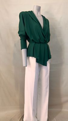 the mannequin is wearing a green top and white pants