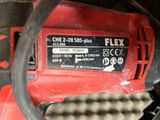 a close up of a red electric drill on a table