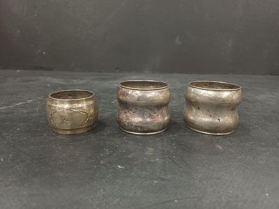 three silver cups sitting on top of a table next to each other