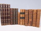 plusieurs vieux livres sont alignés sur une surface blanche