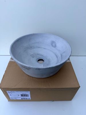 a gray bowl sitting on top of a cardboard box on a white surface