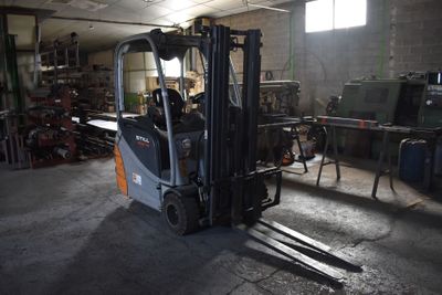 un chariot élévateur dans un garage rempli d'outils