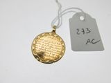 une médaille d'or suspendue à un cordon, avec son étiquette de prix