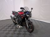 une photo d'une moto rouge et noire garée dans une pièce