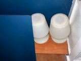 a blue wall in a bathroom with two white bowls on the floor
