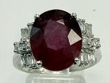 gros plan d'une bague avec une pierre rouge entourée de diamants blancs