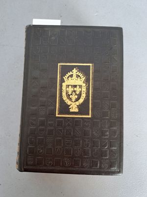 un livre noir orné d'un emblème doré