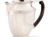 an antique silver teapot with a wooden handle on a white background