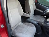 the interior of a small red car with two seats and a steering wheel