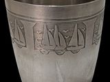 a silver cup that has a design on it